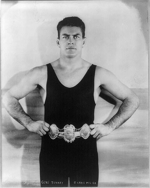 Original portrait of Gene Tunney in black boxing attire holding his championship belt at his waist